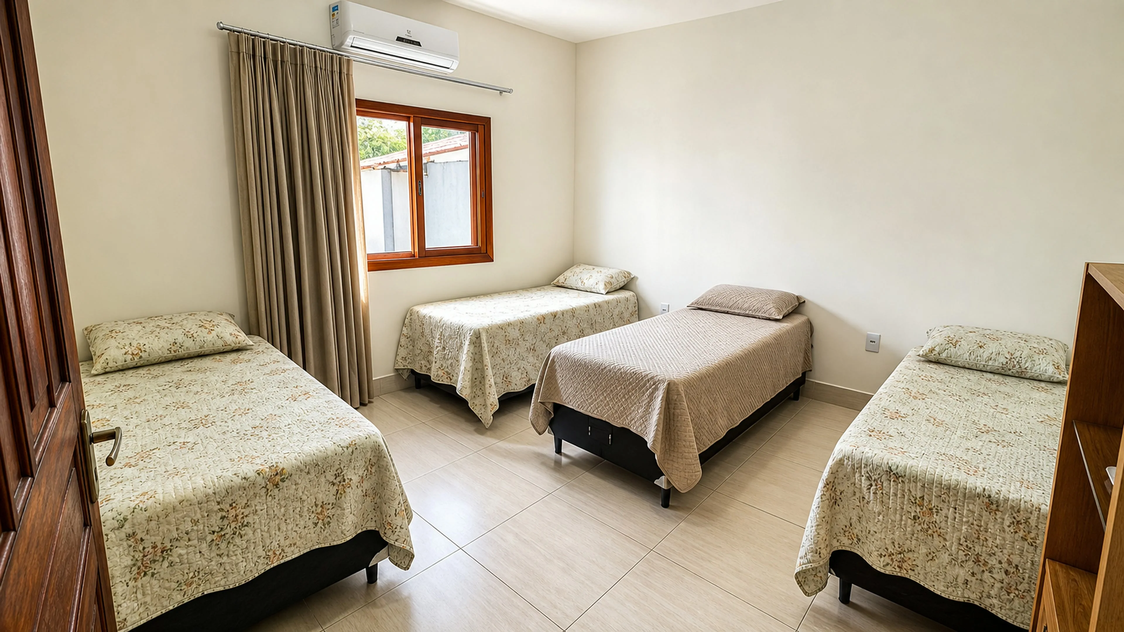 Quarto amplo com quatro camas de solteiro e ar-condicionado na Casa Paulo Filho e Neto