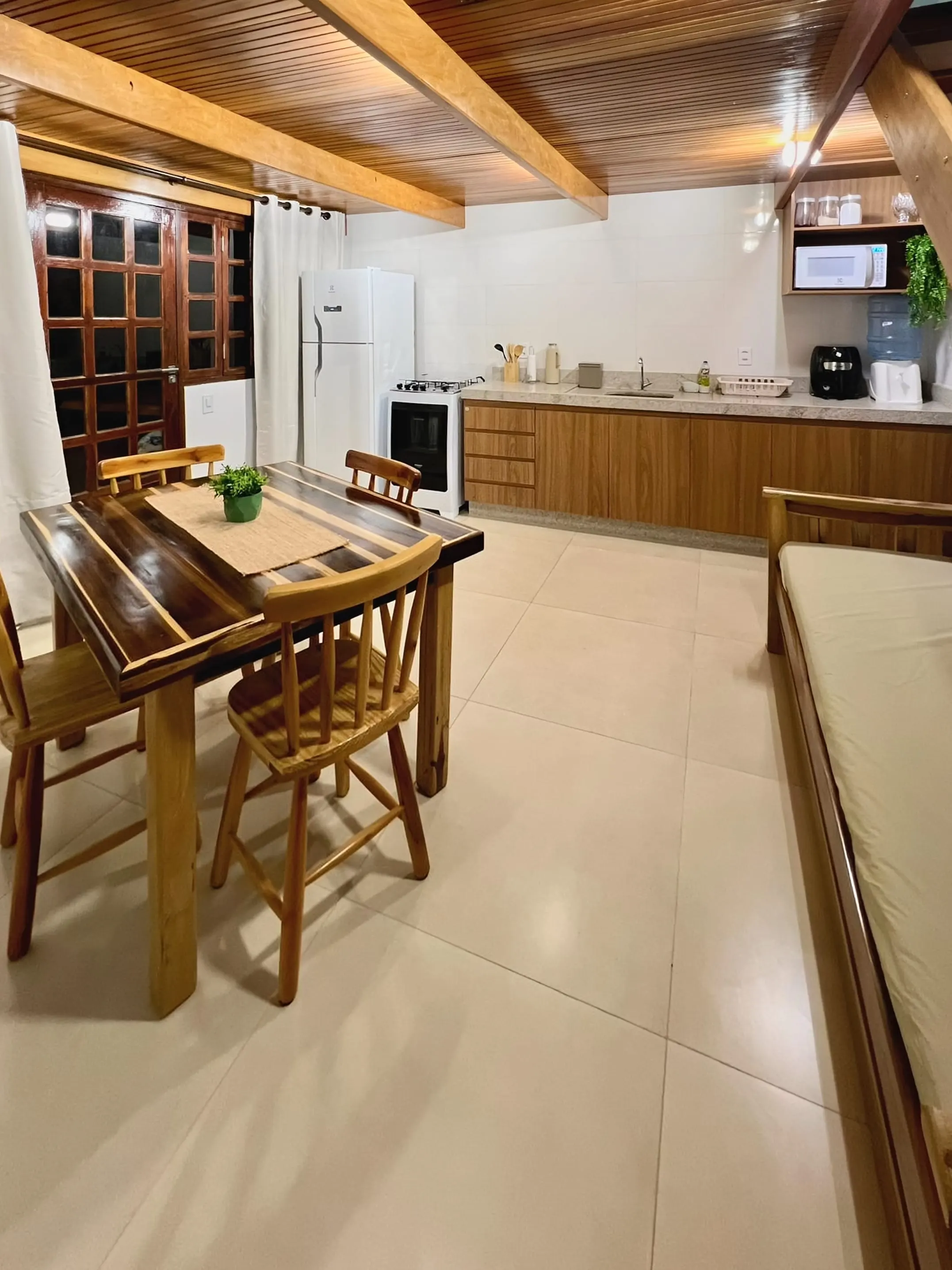 Sala e cozinha no mesmo ambiente no Bangalô Miramar