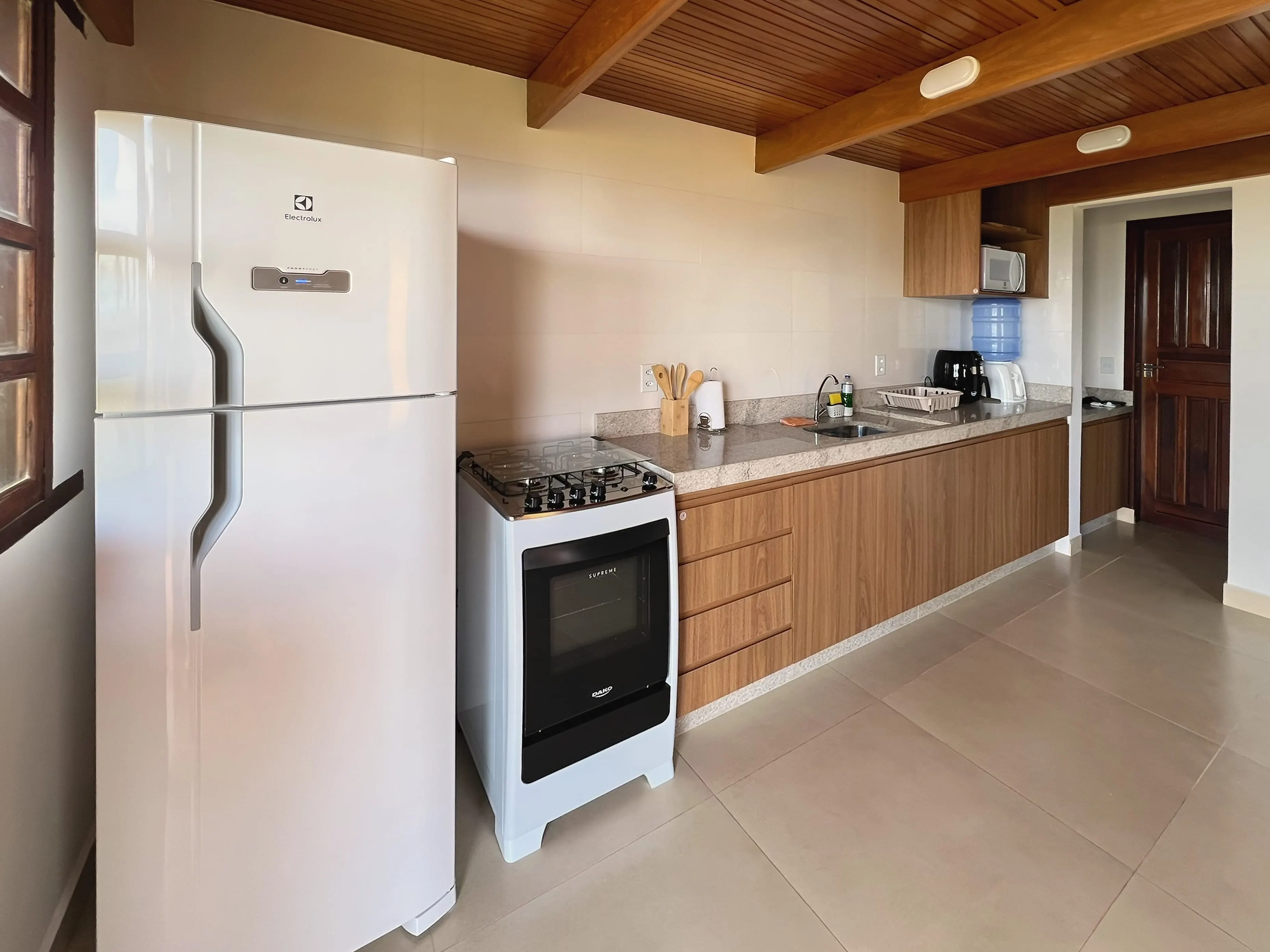 Cozinha do Bangalô Miramar com geladeira, fogão e bancada