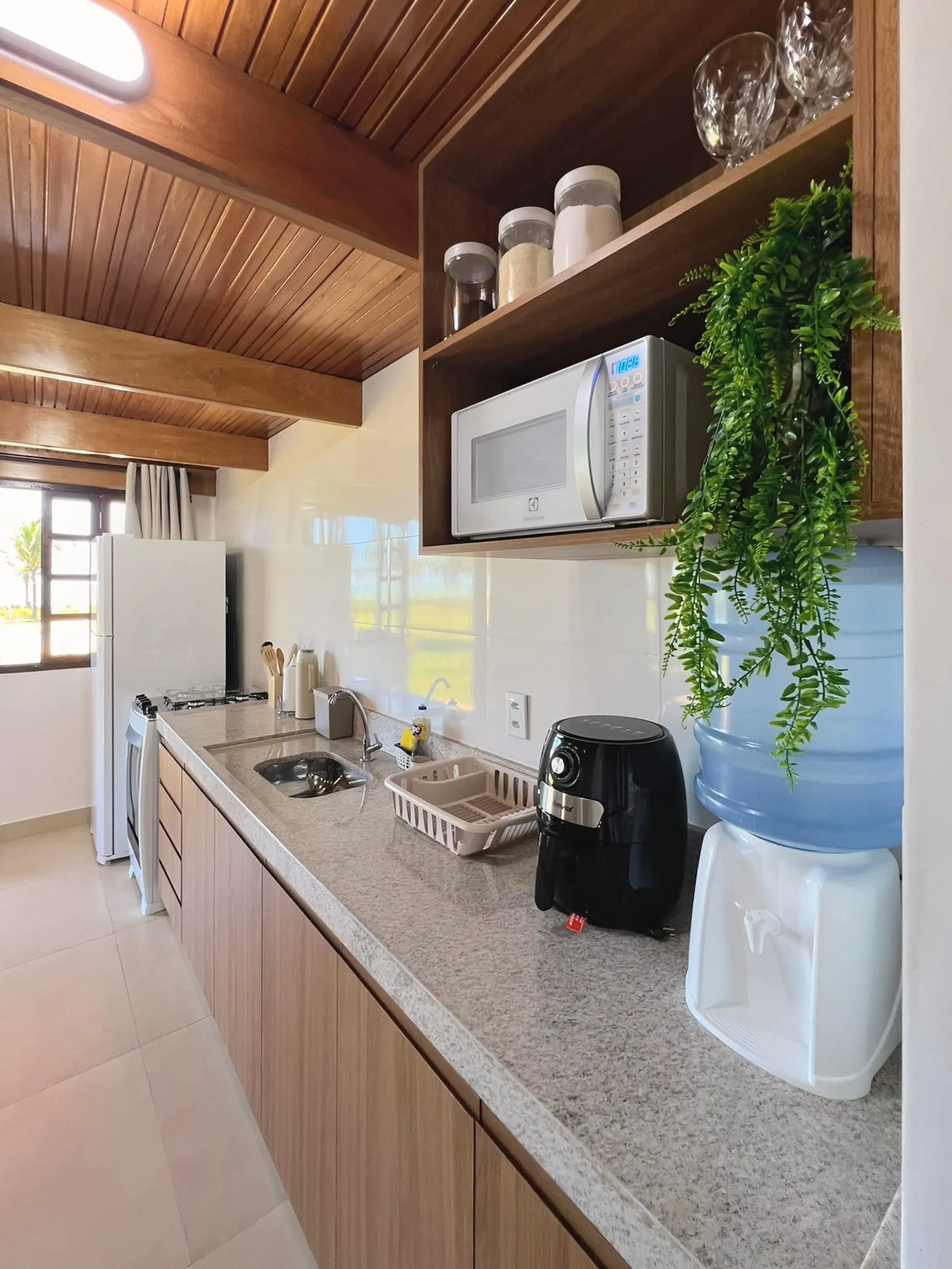 Bancada da cozinha do Bangalô Miramar com micro-ondas e fritadeira elétrica