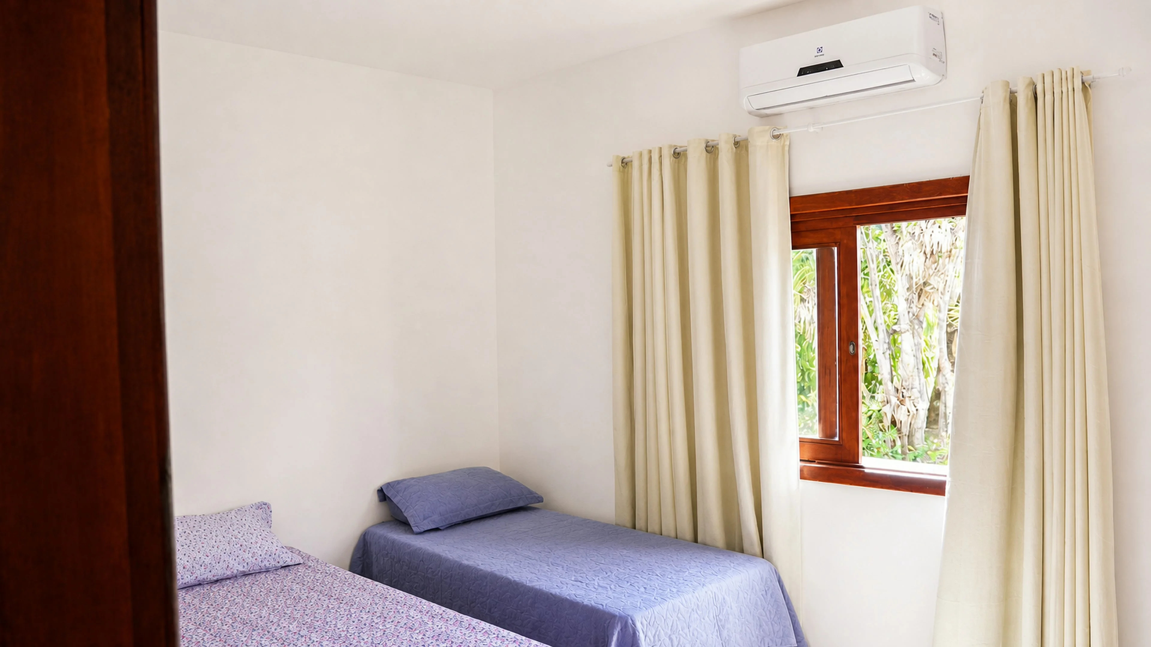 Quarto com duas camas e ar-condicionado na Casa Paulo Filho e Neto