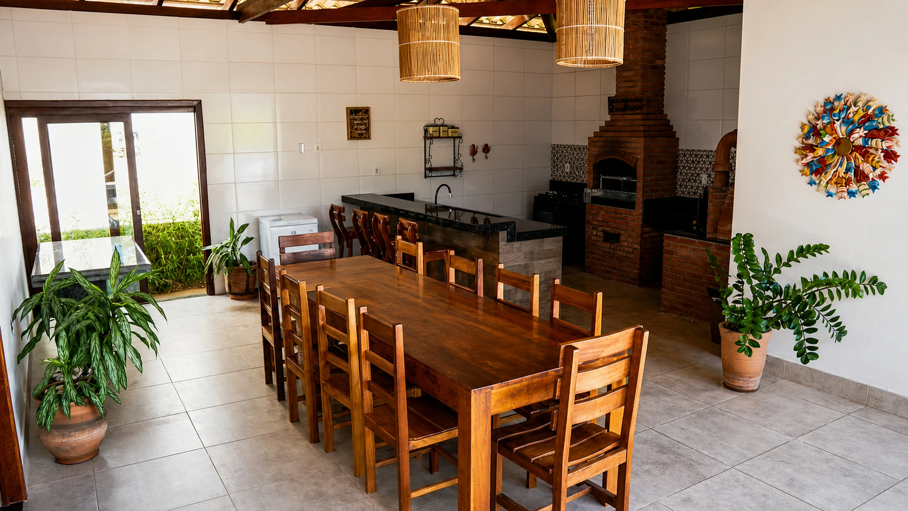 Área gourmet coberta com mesa ampla, bar e churrasqueira da Casa Paulo Filho e Neto