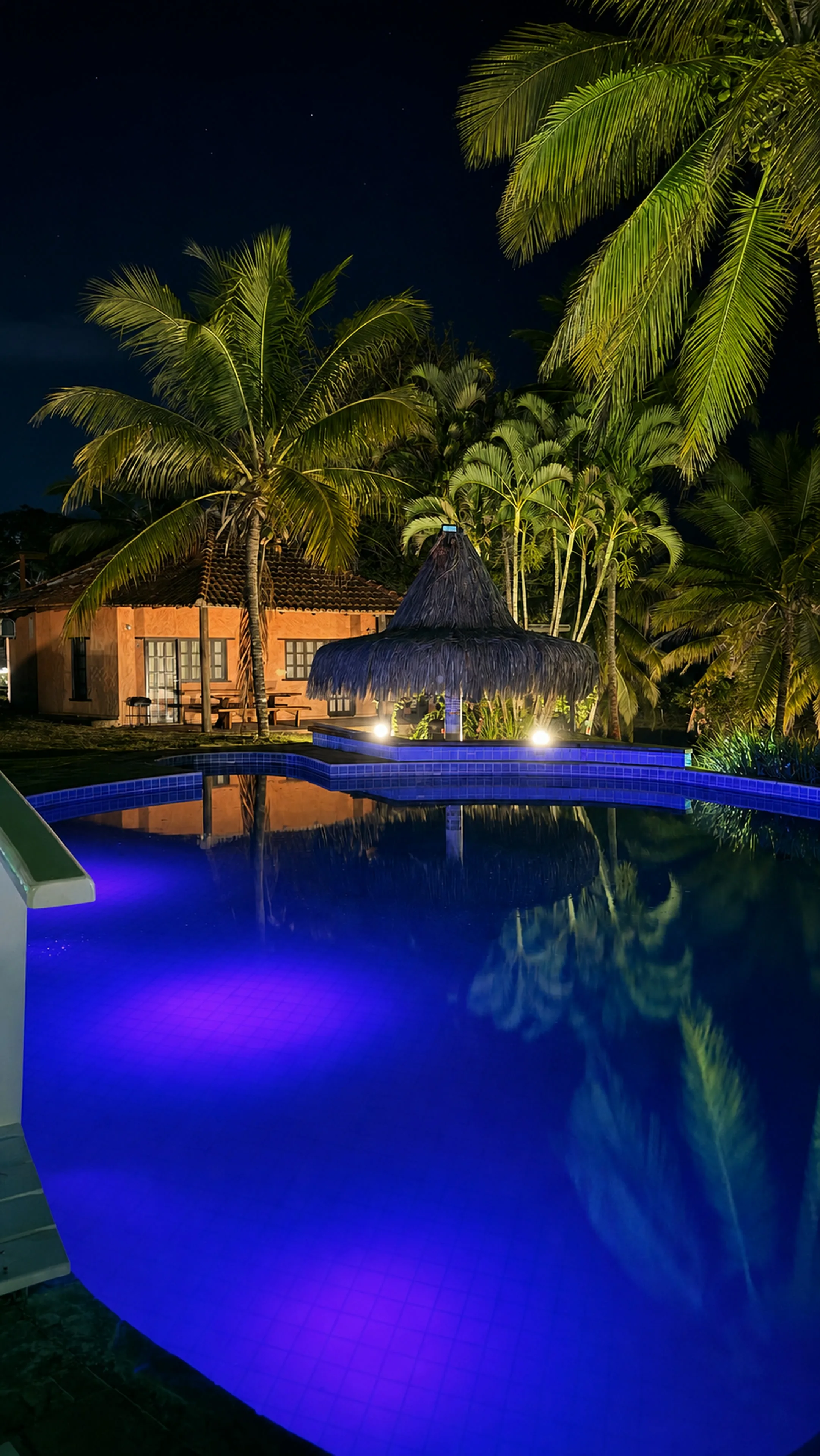 Piscina iluminada à noite no Bangalô Paraíso na Areia