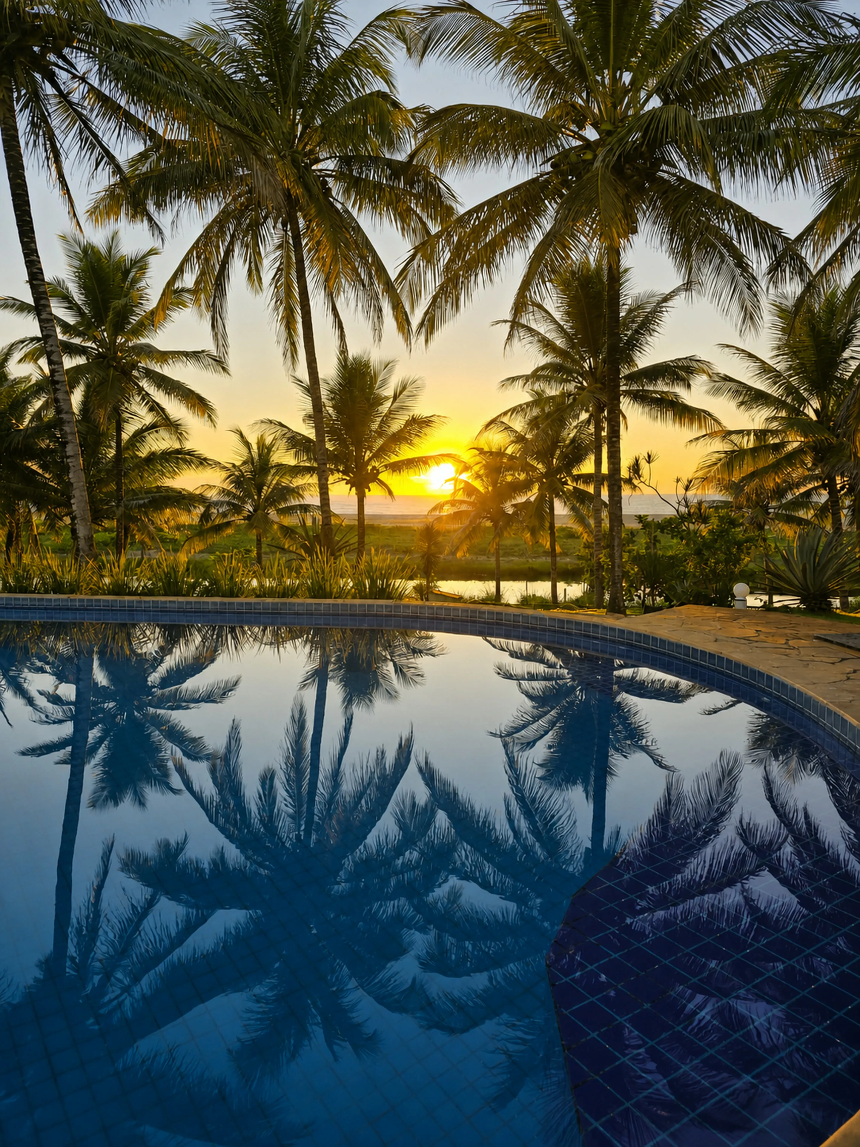 Reflexo do pôr do sol na piscina do Bangalô Paraíso dos Coqueiros