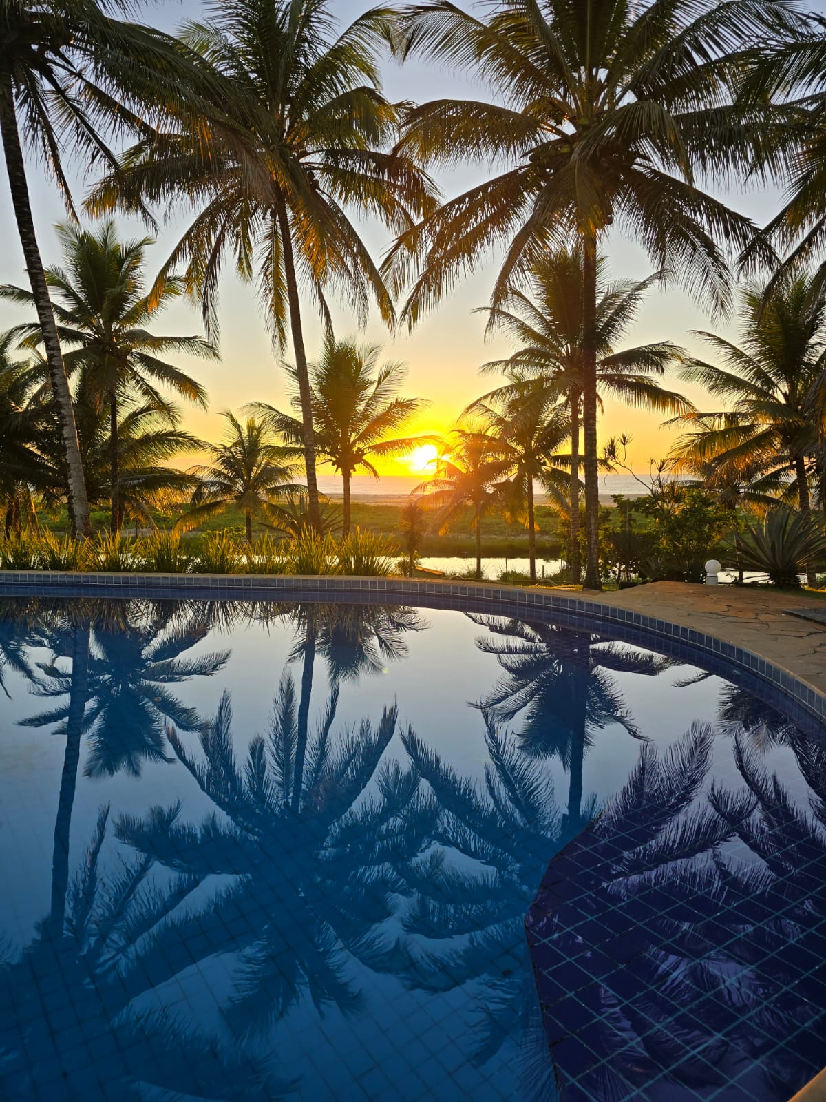 Pôr do sol refletido na piscina dos Bangalôs da Professora Eunice